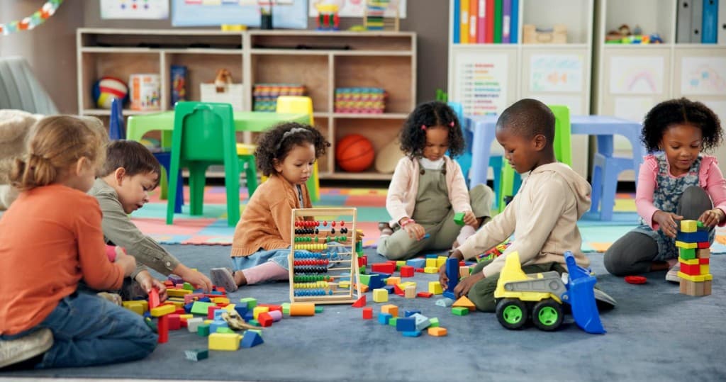 Diverse young children playing together on the floor in a bright pre-K classroom